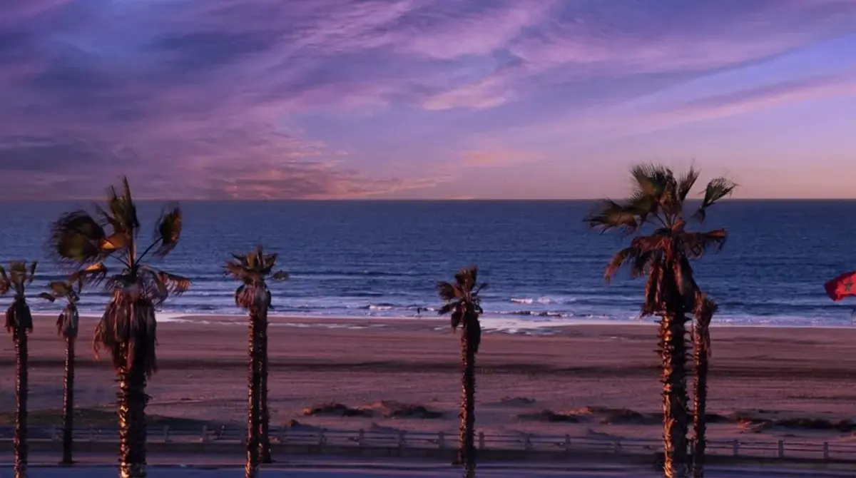 Beautiful sunset over Ain Diab Corniche with a waving Moroccan flag