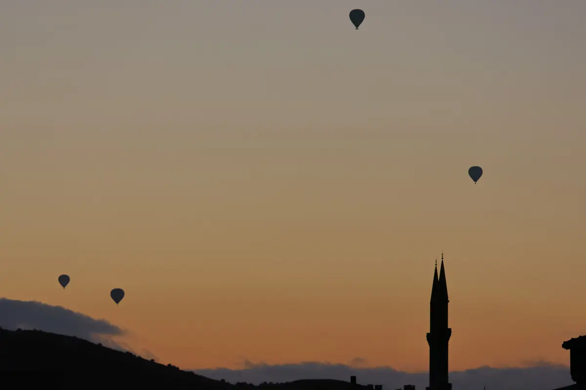 Hot air balloons floating over the Moroccan landscape at sunrise